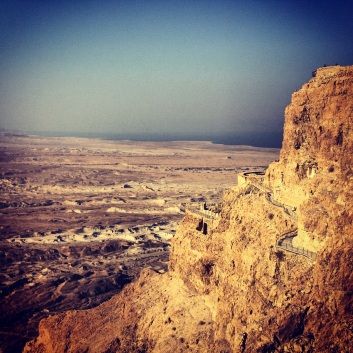 The side of Masada and the Dead Sea in the distance